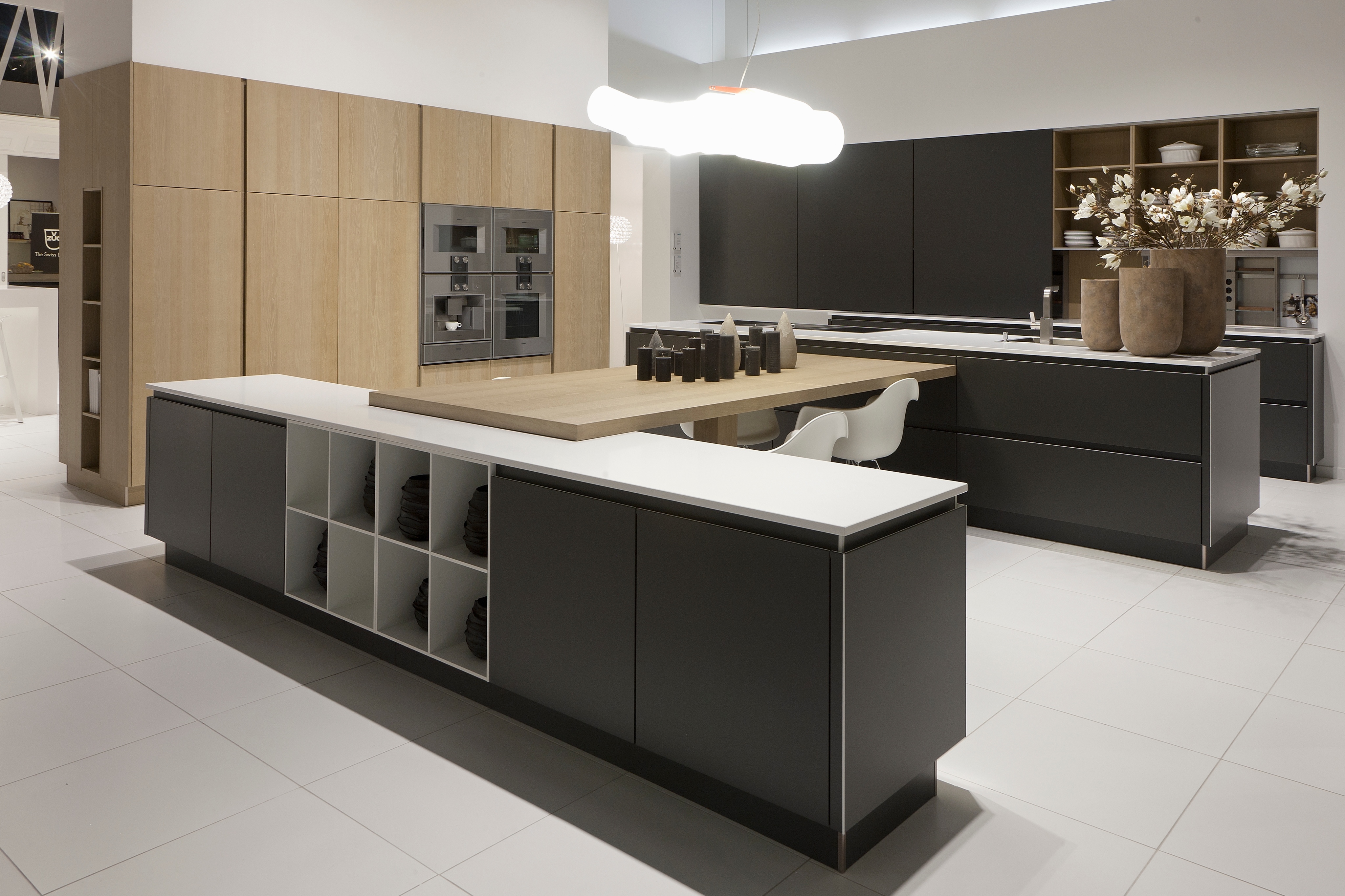 Große Küche mit dunkler Insel mit Regalen auf der Rückseite und einem Hochschrankblock in Holz abgesetzt