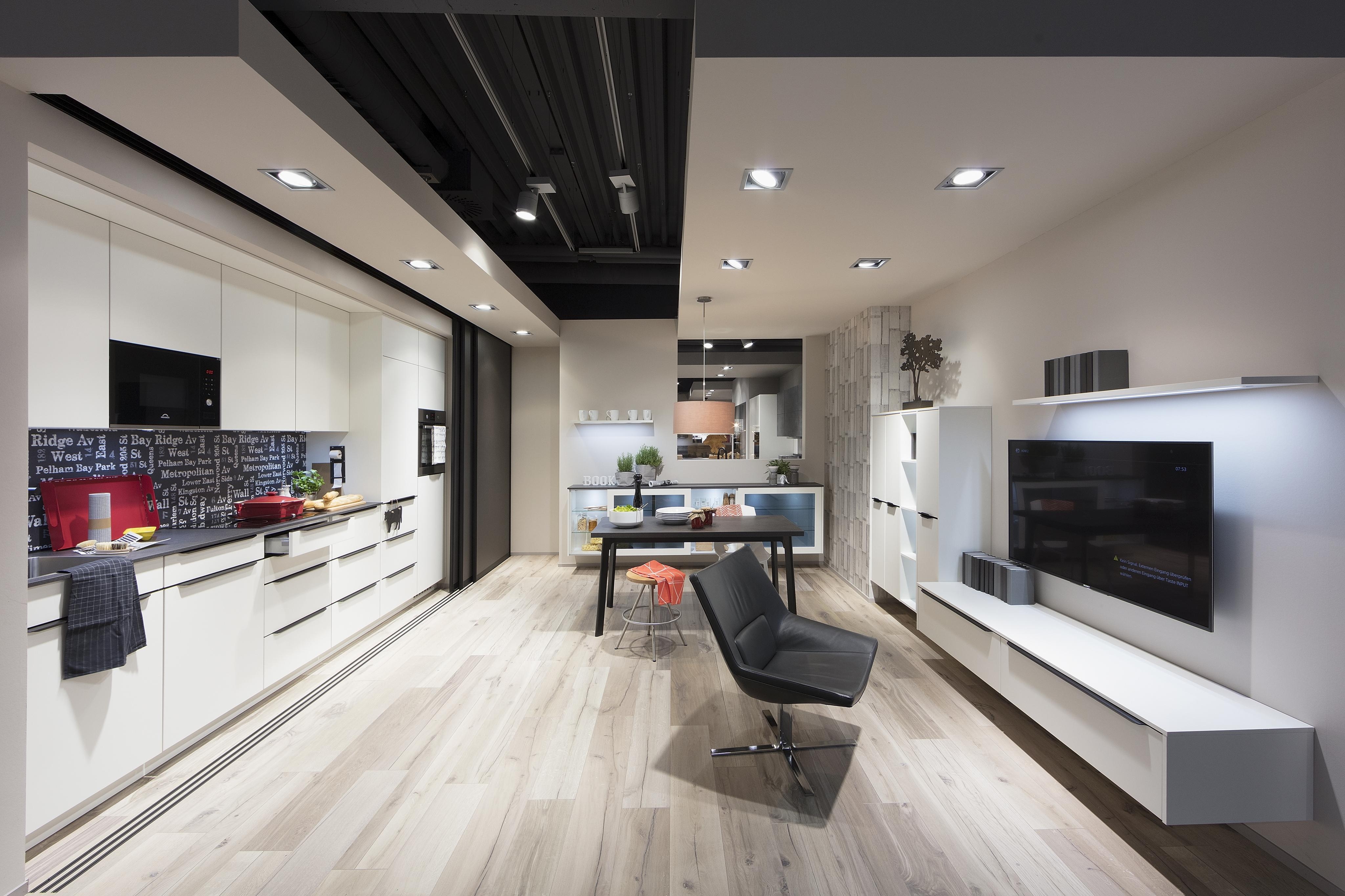 offene Küche mit Küchenzeile auf der linken und TV Board auf der rechten Seite