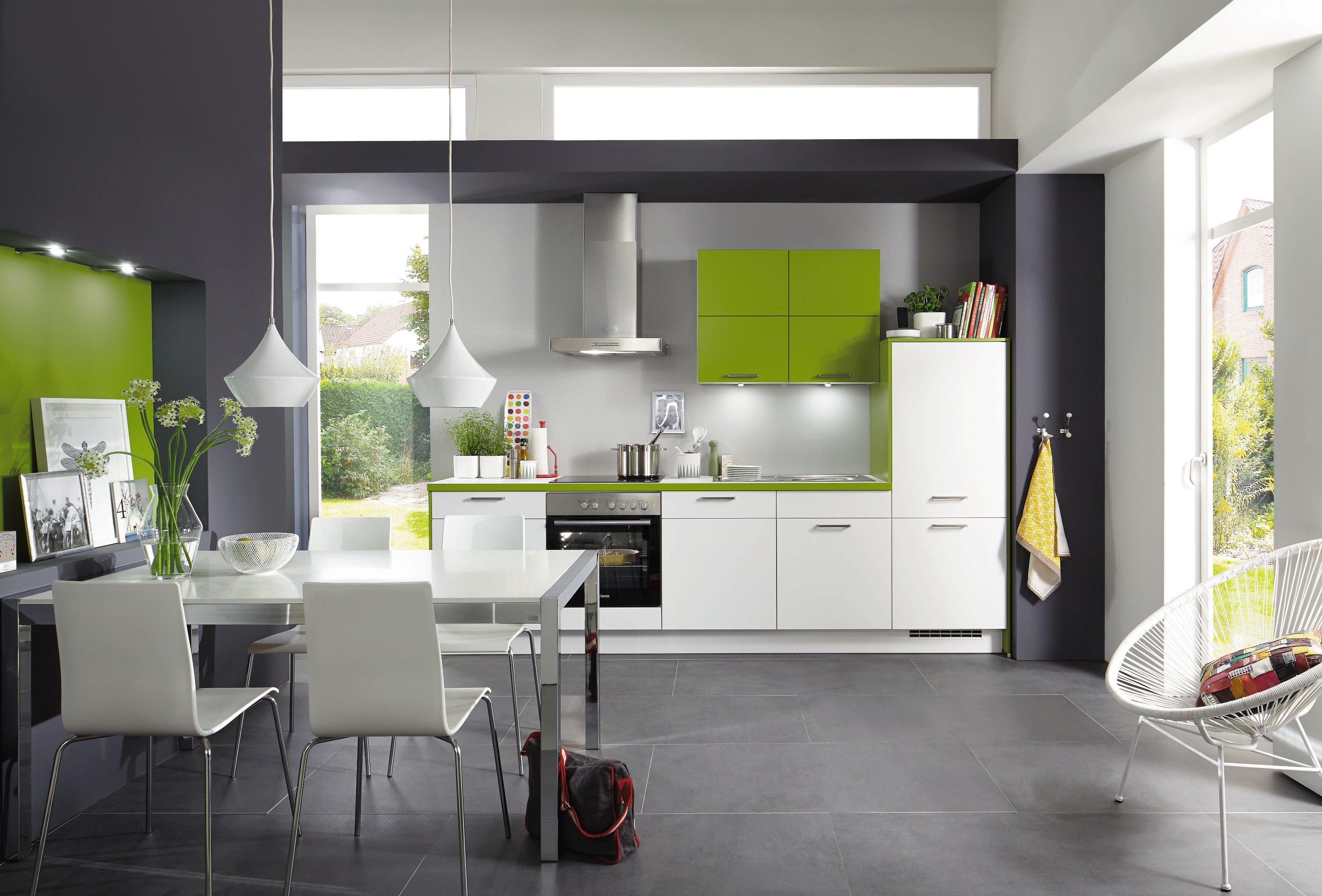weiße Küchenzeile mit grün abgesetzter Arbeitsplatte und Hängeschränken