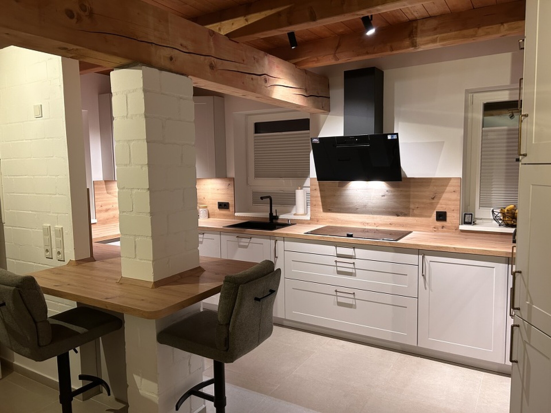 Bild von einer Küche mit einer Inselarbeitsplatte die um Pfeiler herumgebaut wurde