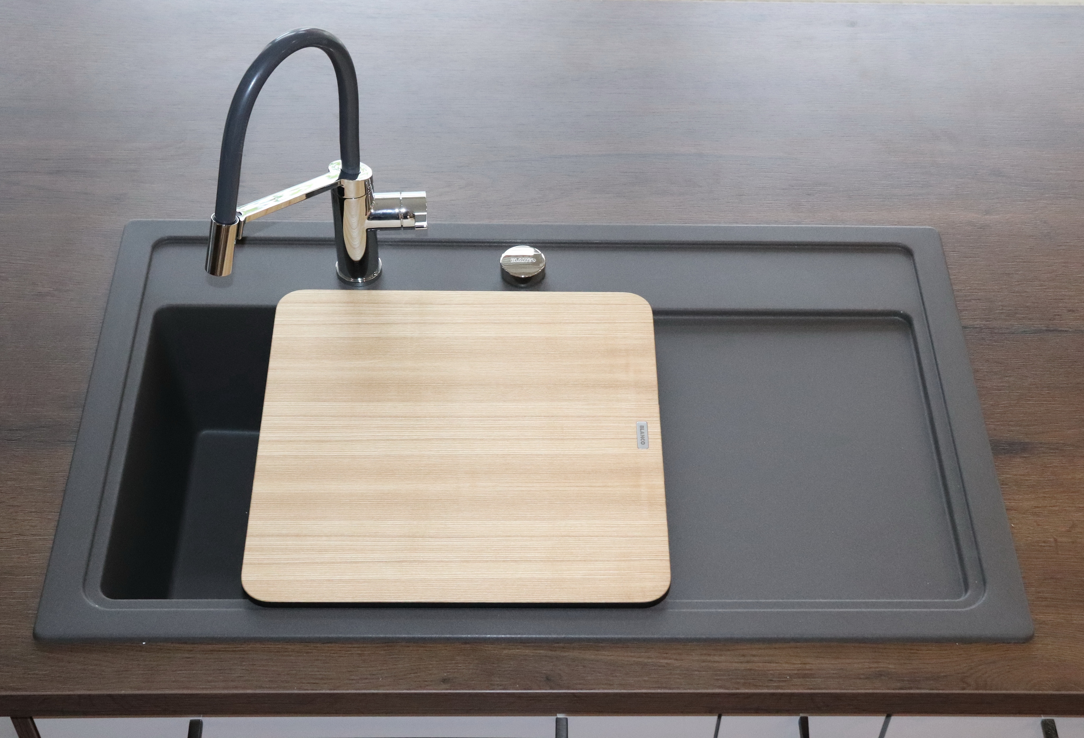 Ausstellungsbild - Detailbild graue Spüle mit einer Holzablage