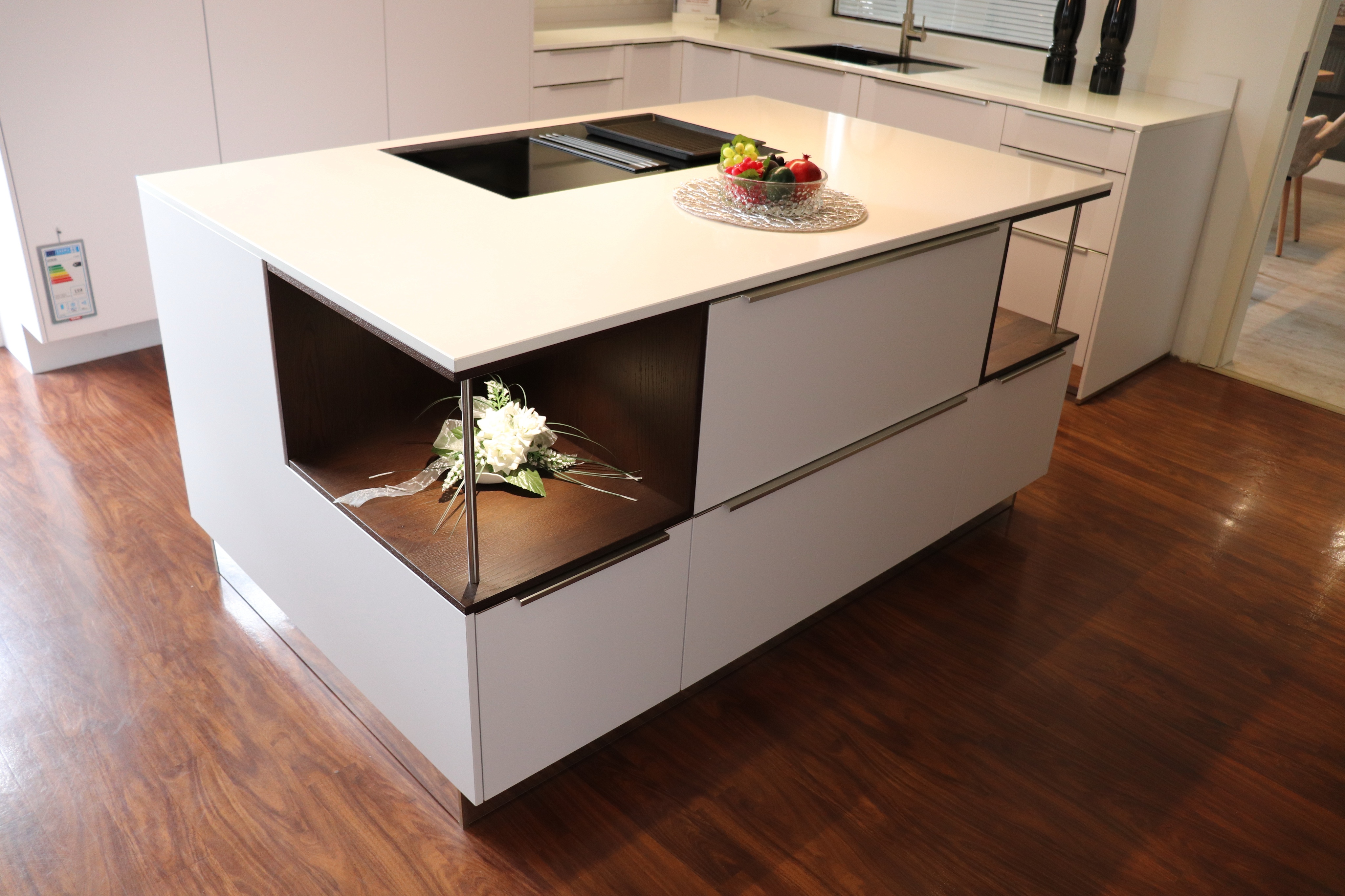 Ausstellungsbild - weiße Kücheninsel mit eingesetzten Regalen