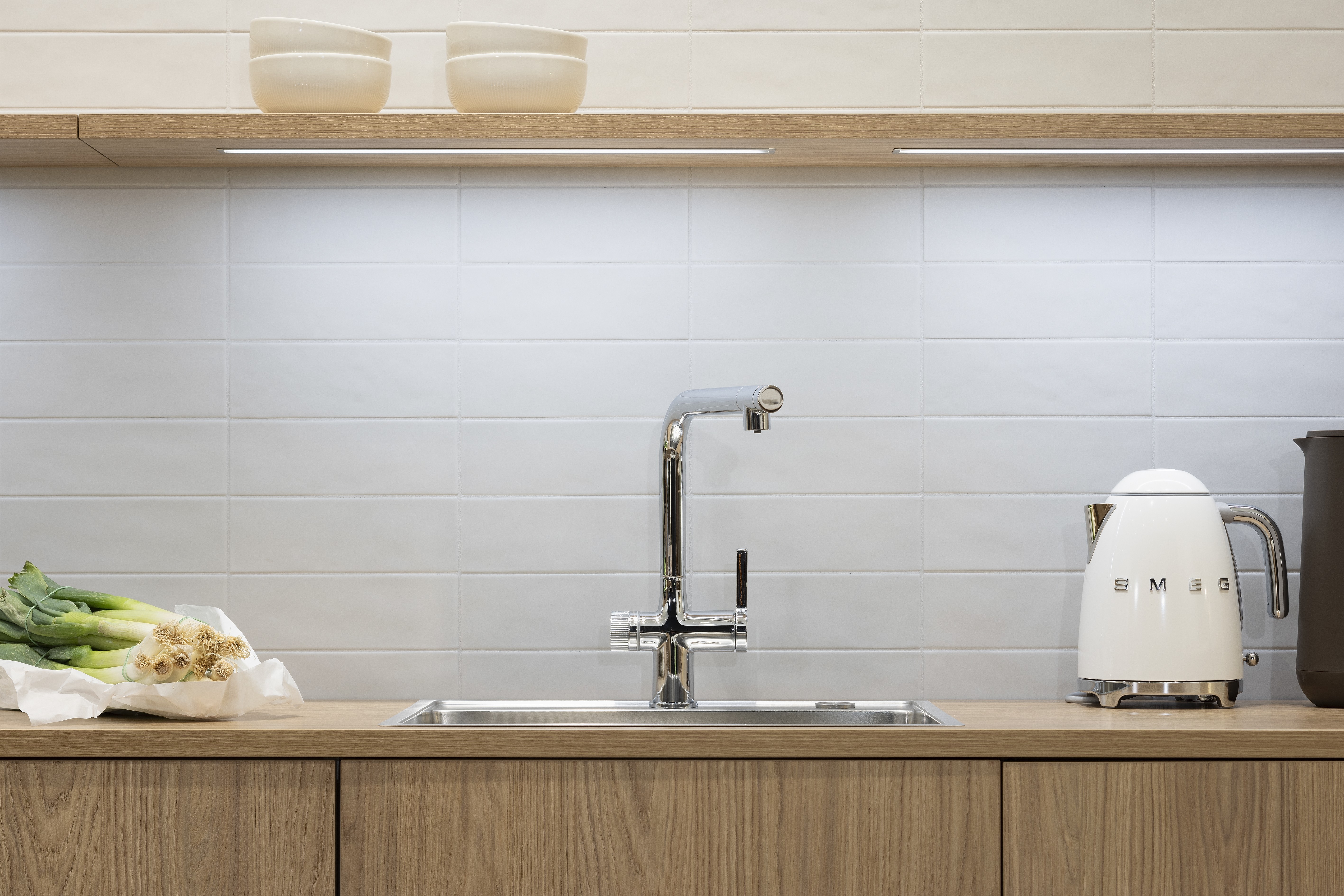 APL: TOP Granit Perlato und Goldeiche Front: neoLEAF Goldeiche Korpus: Graphit Griff: PTO und Ziergriff Weiß matt  Geräte: AEG Armatur: Reginox Spüle: Reginox   Features: Echtholzfront, Fliesen, moderne Nischenplanung, Tischlösung mit Granitplatte durchgängig in Thekenlösung, Edelstahlbecken, skandinavisches Design, Designgriff, Sideboardlösung in Goldeiche, verschiedene Arbeitshöhen (Kochen + Arbeiten), stylische Lichtlösung in Nische, Gemütlichkeit durch Teppich in der Küche (Trend 2025/26),Wassersprudler