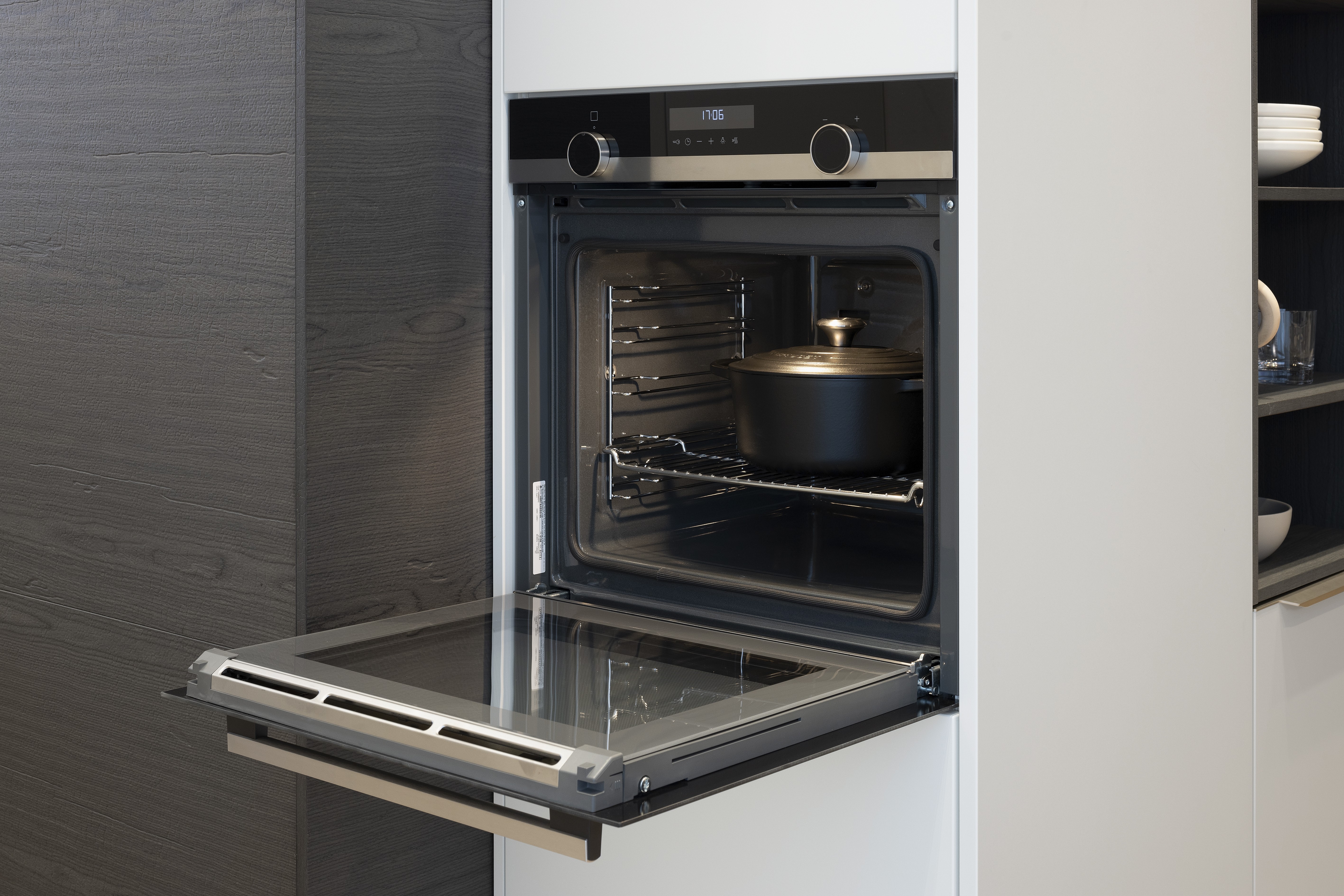 APL: Beton NP 12 mm Front: SoftLack Weiß softmatt Front: dunkles Holz NB Sepia Korpus: Weiß Griff: PTO und Edelstahloptik Geräte: Siemens, Kochfeld mit Abzug elica Armatur: Nobili Spüle: Franke    Features: Appartementküche, 90er Höhe, Materialkombi Weiß matt und dunkle Holzoptik mit Syncronpore (Oberflächenhaptik), Arbeitsplatz, Einbauschränke mit Sitzbank, Backofen in gedrehtem Schrankelement (Optik) somit kein Backofen in Küche sichtbar.