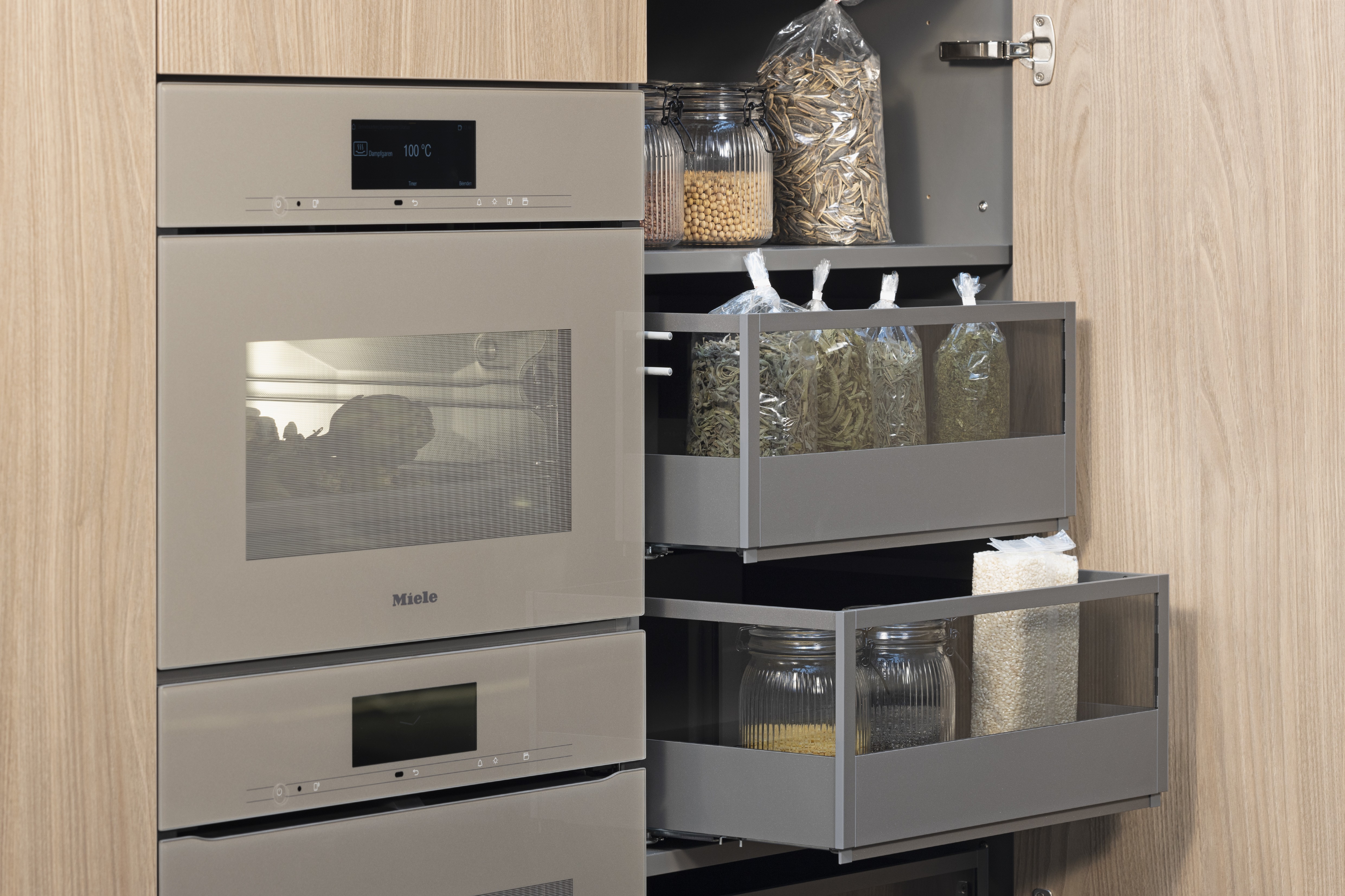 APL: 144 Granit-beige Repro 25 mm Front: AV 2020 Luxor-braun Melaminharzbeschichtung (PUResist, PURemmision) Korpus: 4059 Titan Griff: PTO, Kehlleiste Graphit gebürstet Kehlleiste Graphit gebürstet Geräte: Miele, SMEG Armatur: Blaupunkt Spüle: Blaupunkt  Features: APL = Nischenrückwand, Griffleiste beleuchtet, Thekenlösung, Oberschrank beleuchtet, Auszüge mit Glas, klare Linienführung auch an den Wangen, Front modern kassettiert, Theke ohne Sockel, architektonische Linienführung, Elektrogeräte Pearlbeige.