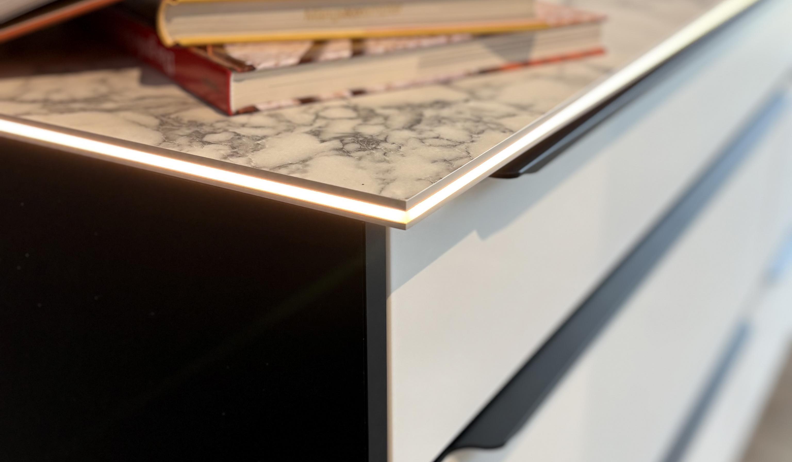 Aufgeschlagene Bücher liegen auf einer modernen Küchenarbeitsplatte.